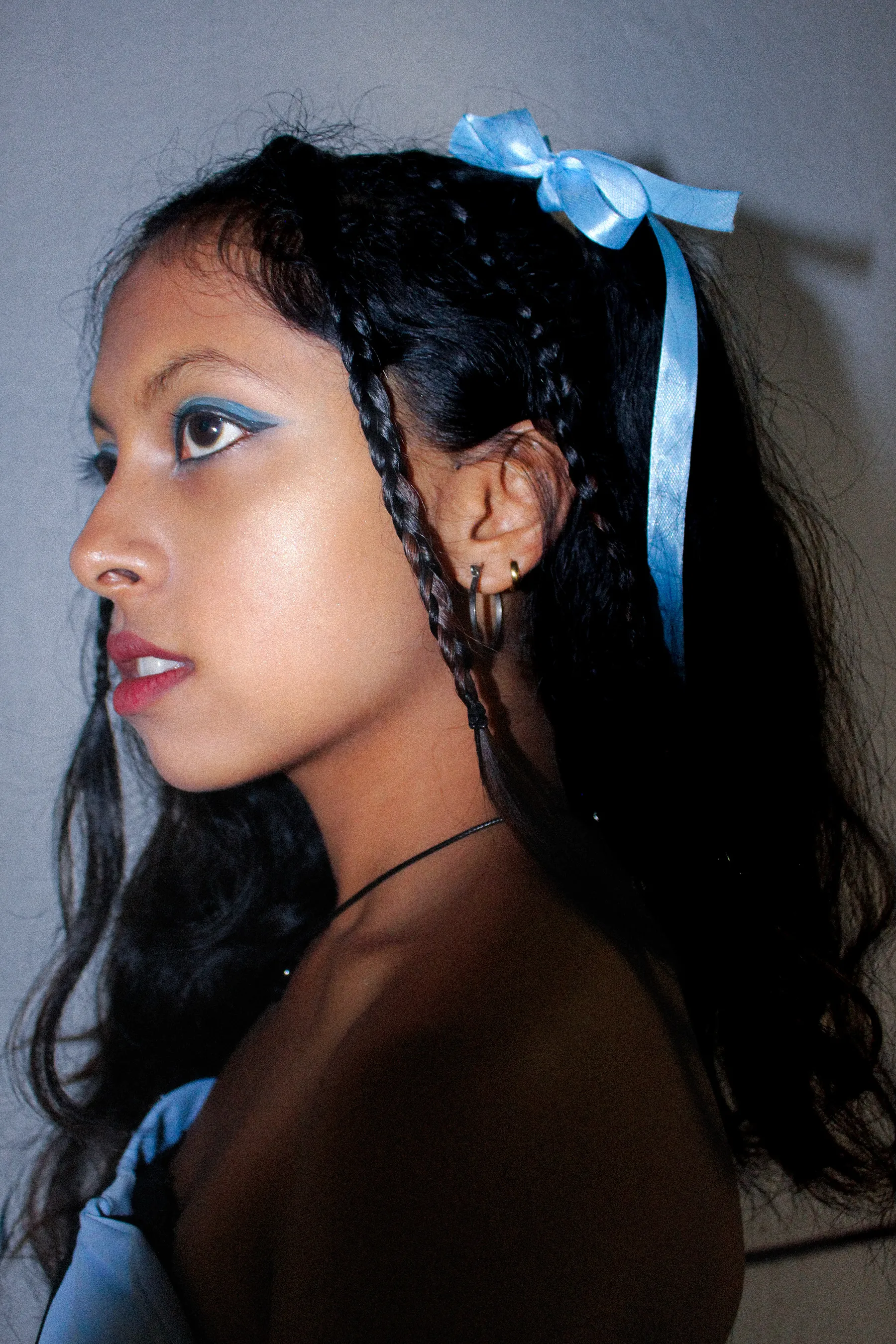 Profile portrait with blue ribbons in her braids