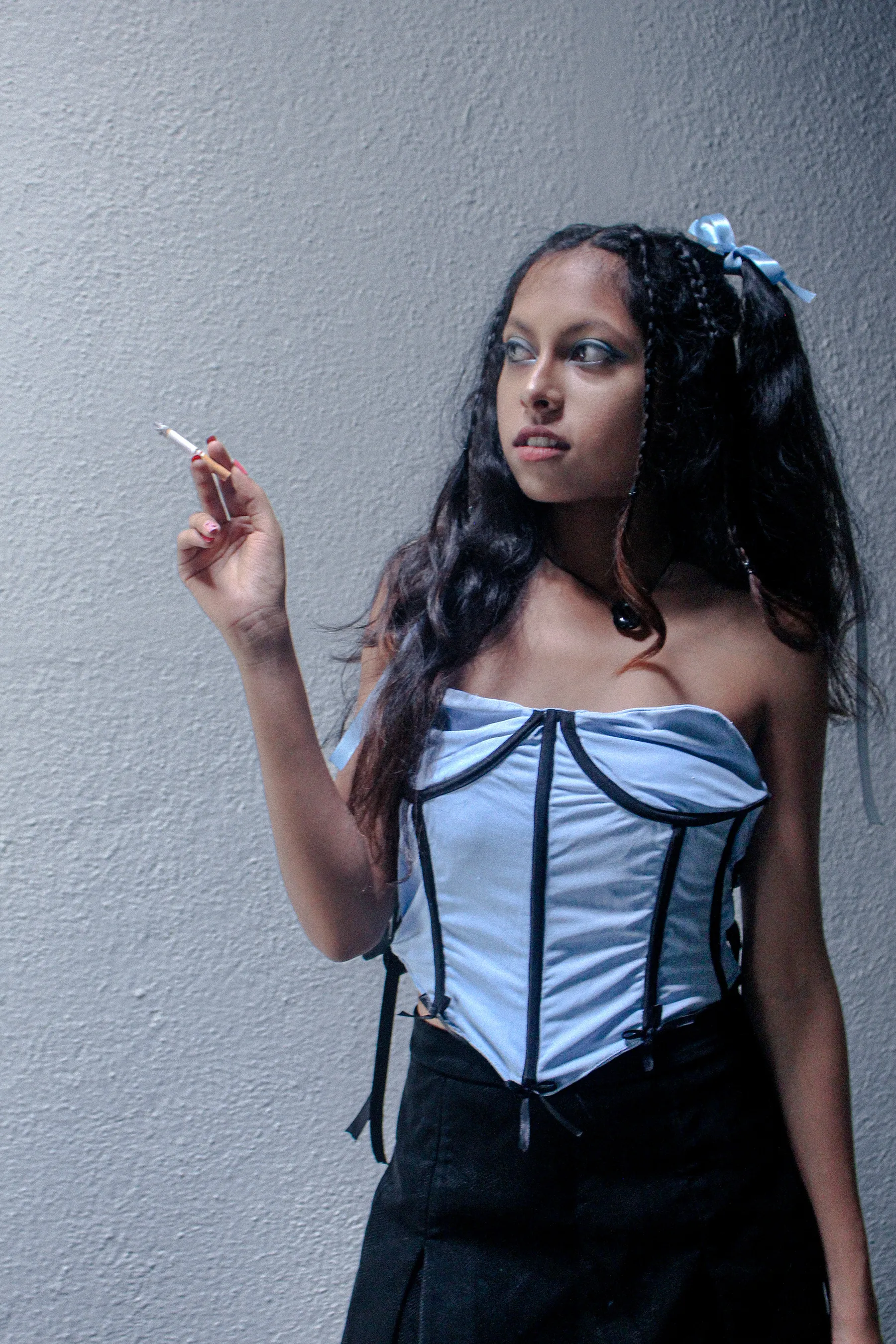 The model in the corset holding a cigarette