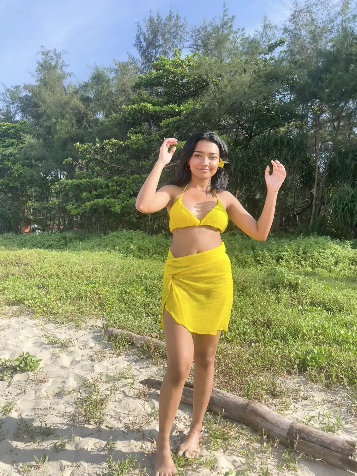The model in the dunes with her arms raised