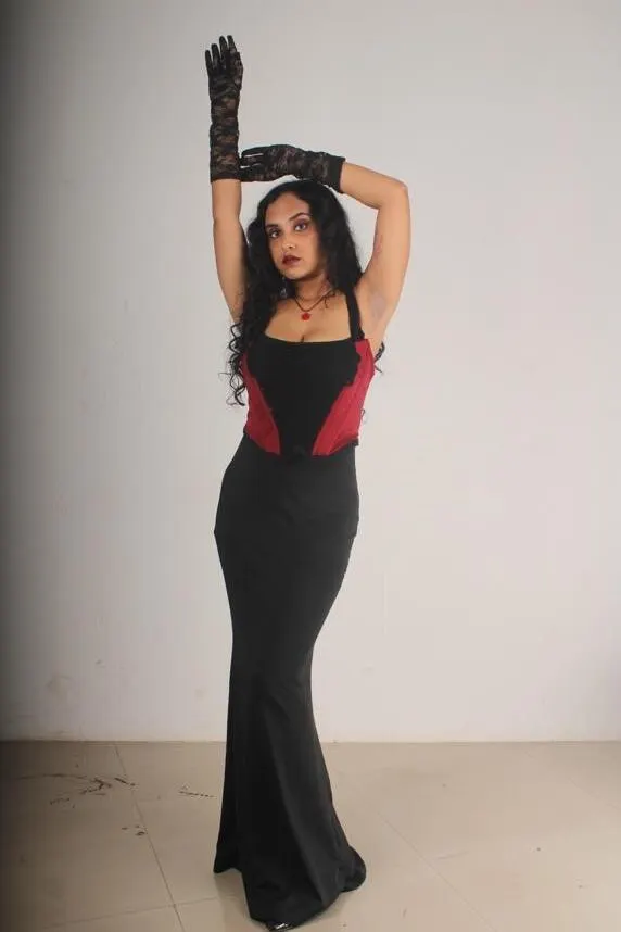 Full-length view with arms raised and long black gloves