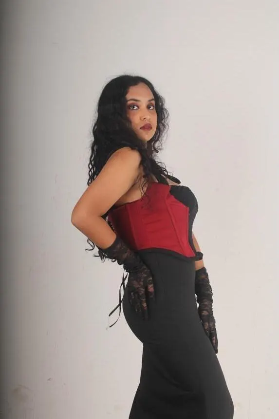 The model in the red and black corset and long black skirt