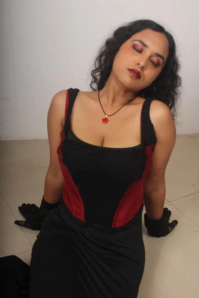 The model seated on the floor in the corset
